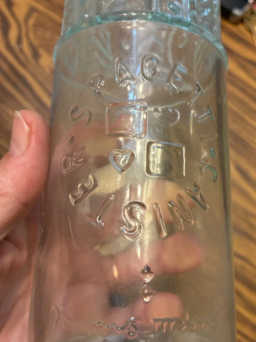vintage glass spaghetti canister features an embossed circular logo